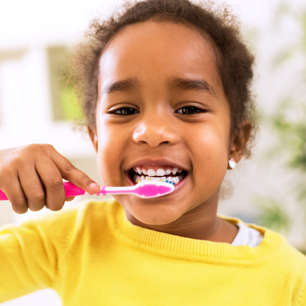young girl brushing her teeth
